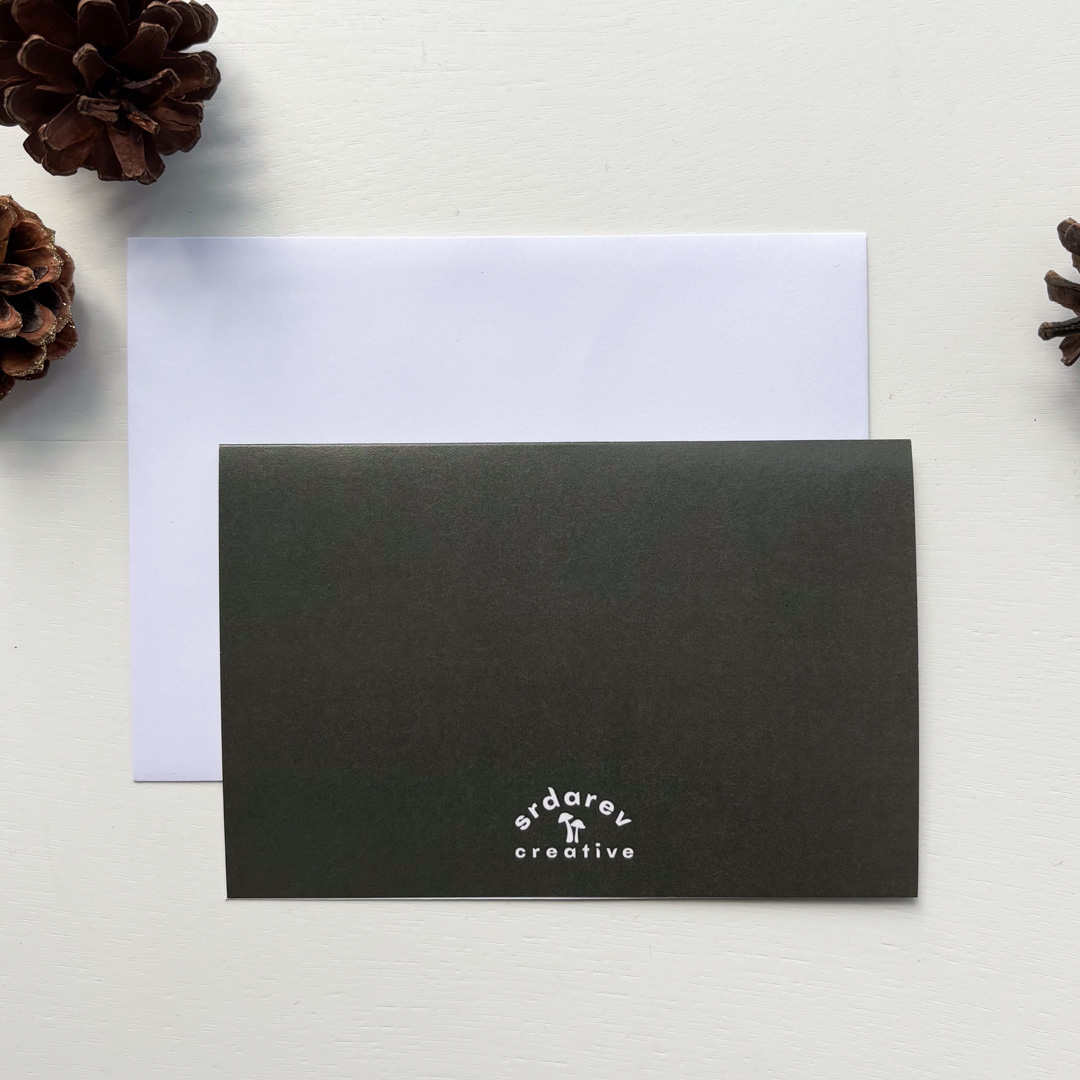 The background is white and there are three pinecones on the edges. There's a white envelope with the back of a card that's dark green with the "Srdarev Creative" logo on it.