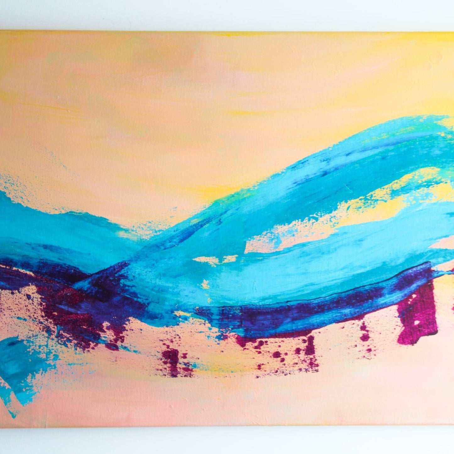 A painting that's mostly yellow with a blue and purple swash going through it on the bottom.
