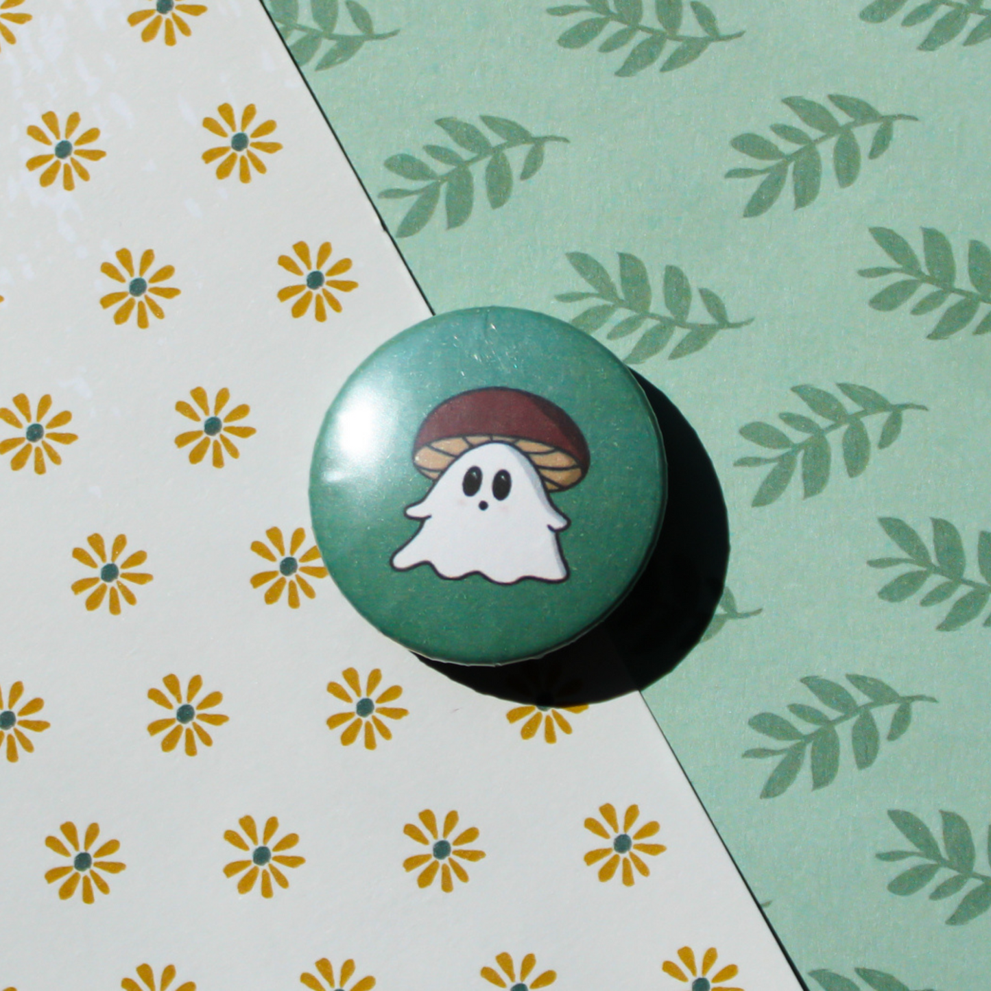 A flower and leaf patterned background with a green circle button with a shocked white ghost wearing a red mushroom cap.