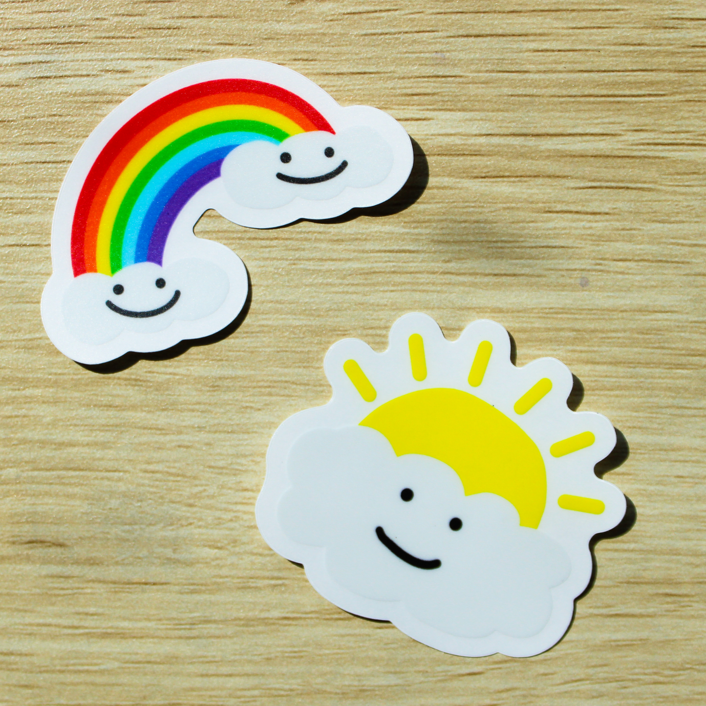 A wooden background with a happy rainbow cloud and a happy sun cloud on top.
