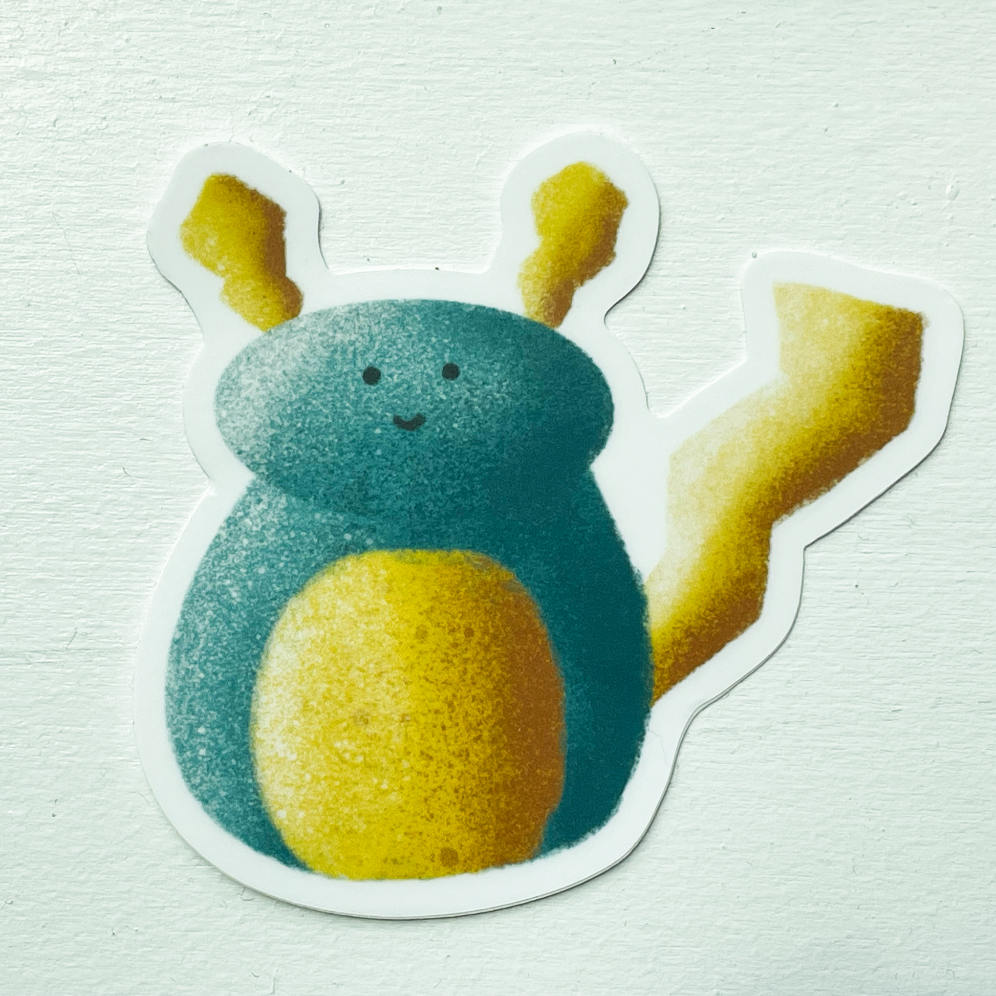 Azul the Monster sticker, a large round blue monster with yellow ears, tail, and stomach with a very cute smile on his face on a white background